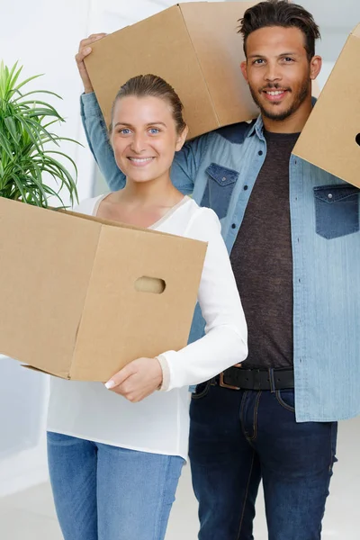 Jovem casal carregando suas caixas — Fotografia de Stock