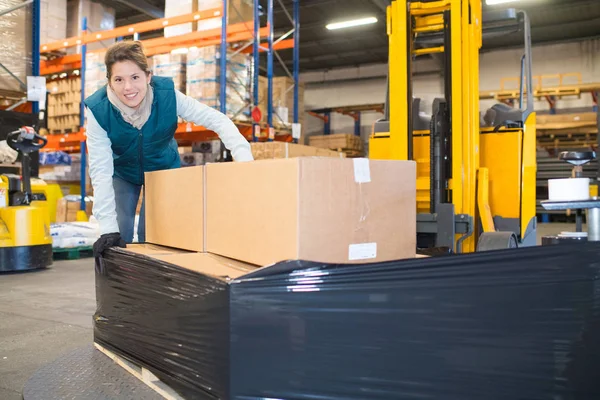 Arbetstagare med lådor i ett lager — Stockfoto