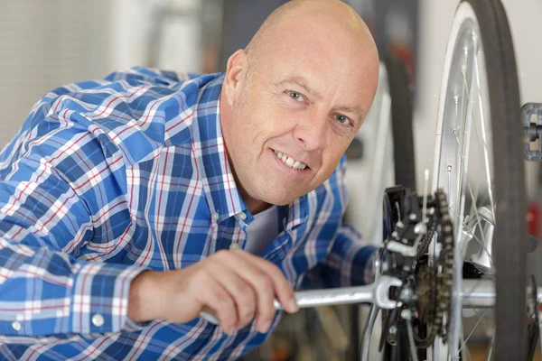 Mann repariert Fahrrad mit Schraubenschlüssel — Stockfoto