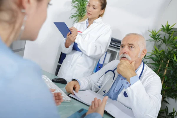 Жіночий пацієнт консультує старшого лікаря — стокове фото