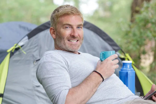 Uomo bere caffè fuori tenda — Foto Stock