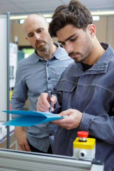 Dois trabalhadores manuais verificando notas — Fotografia de Stock