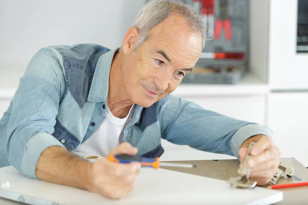 Senior assembling furniture at home — Stock Photo, Image