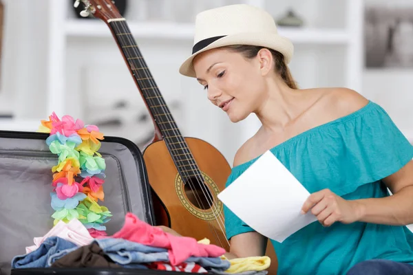 Retrato de una mujer y lista de embalaje de viajes — Foto de Stock