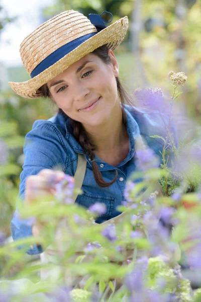 꿈같은 표정으로 정원을 가꾸는 젊은 여성 — 스톡 사진