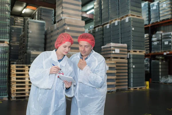 Ve skladu stáli dva dělníci z továrny — Stock fotografie