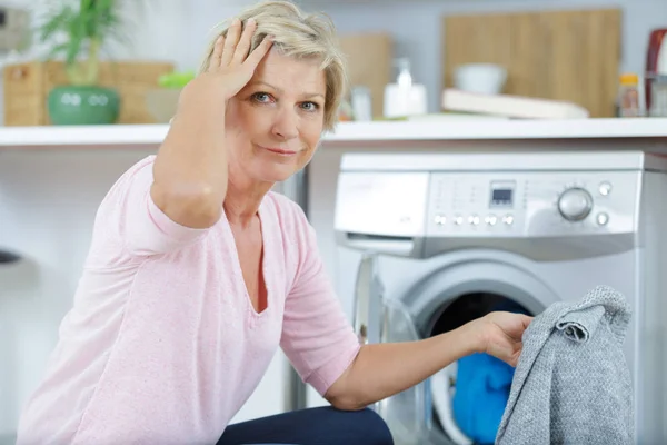 Femme âgée faisant la lessive avec machine à laver — Photo