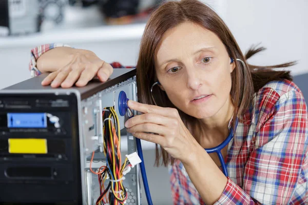 Technik żeński stosujący steteoskop do mocowania komputera — Zdjęcie stockowe