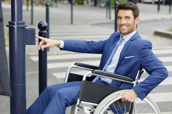 Niepełnosprawny przedsiębiorca na wózku inwalidzkim przejeżdżający przez ulicę — Zdjęcie stockowe