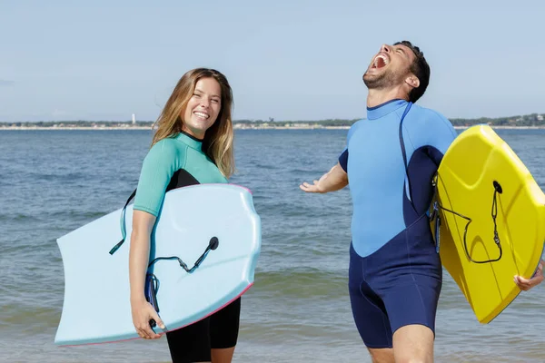 Couple of surfers at the beach — Stock Photo, Image