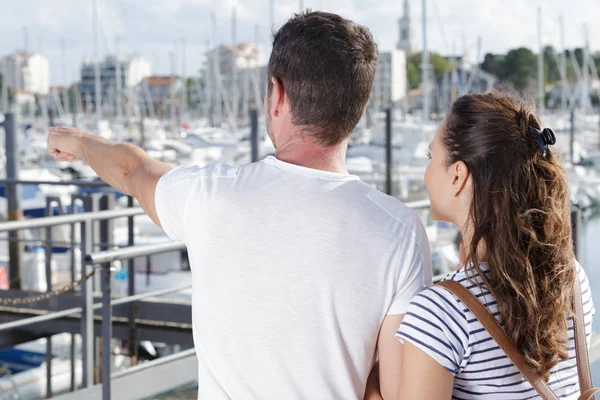 Pár dívá ven přes port muž ukazuje do dálky — Stock fotografie