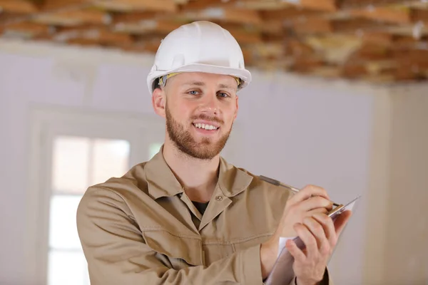 Hombre constructor sostiene un portapapeles —  Fotos de Stock
