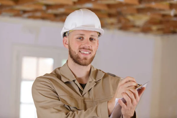 Homme constructeur détient un presse-papiers — Photo