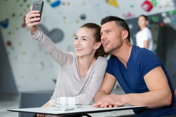 Pareja en centro de actividad cafetería tomando una selfie —  Fotos de Stock