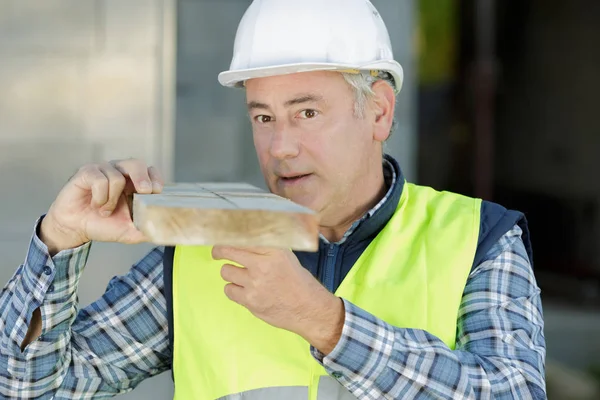 Bauunternehmer trägt einen Balken — Stockfoto