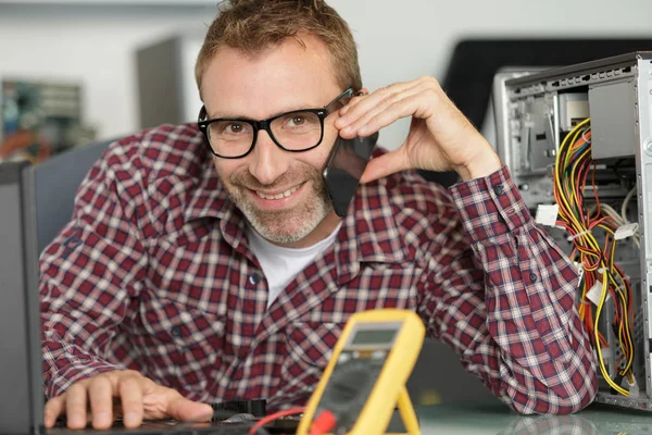 Computertechniker am Telefon repariert kaputten Desktop — Stockfoto