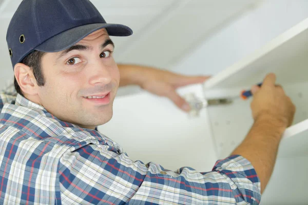 Close-up de um trabalhador masculino durante a instalação de cozinha-mobiliário — Fotografia de Stock
