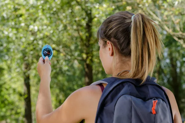 Vrouw met kompas is op zoek naar een goede manier in bos — Stockfoto
