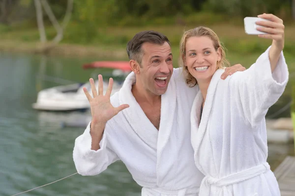 Couple in bathrobes taking selfie photograph — Stock Photo, Image