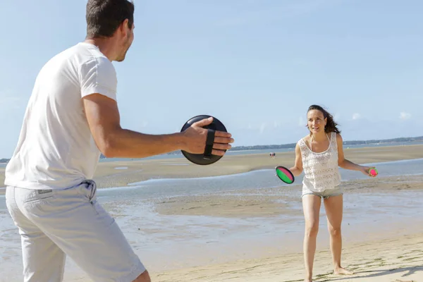 해변에서 공놀이를 하는 부부 — 스톡 사진
