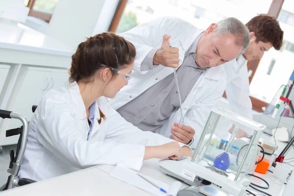 Team of scientists in a laboratory working on chemical testing — Stock Photo, Image