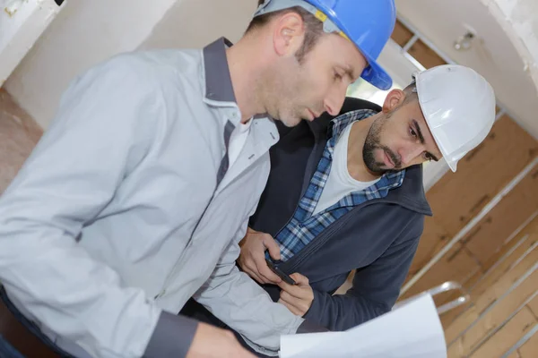 Zwei Bauarbeiter in Uniform im Gespräch — Stockfoto