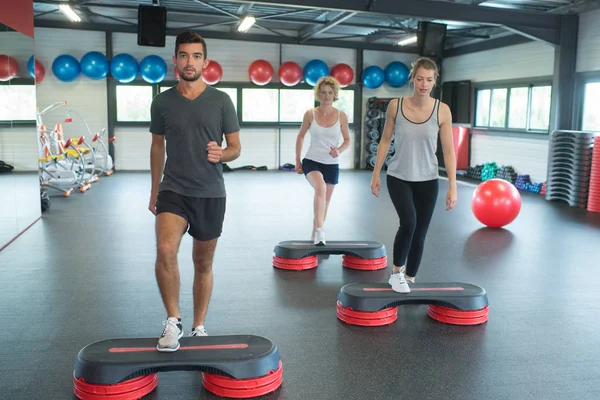 Groep mensen buigen van de benen op stap platformen — Stockfoto