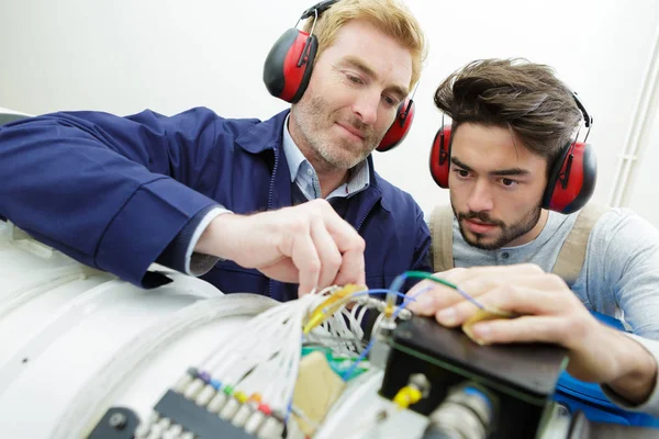 Dois técnicos trabalhando em uma máquina — Fotografia de Stock