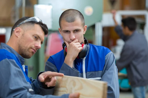 Homme regardant le bois dans l'atelier — Photo