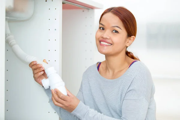 Впевнена жінка ремонтує раковину у ванній вдома — стокове фото