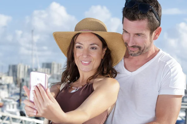 Arka planda limanı olan bir çift selfie çekiyor. — Stok fotoğraf