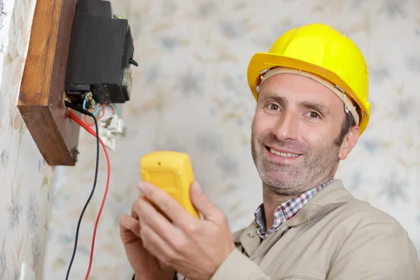 Um eletricista instala um soquete — Fotografia de Stock