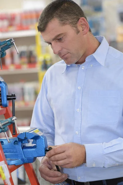 Handyman selecting a product at a hardware store — Stock Photo, Image