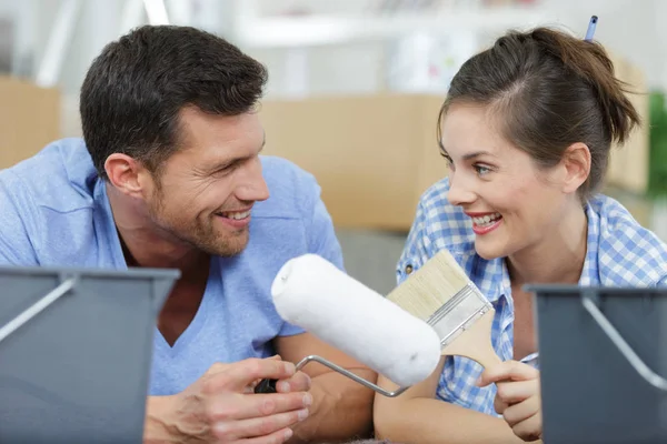 Jong stel in hoofdbanden met verfrollen — Stockfoto