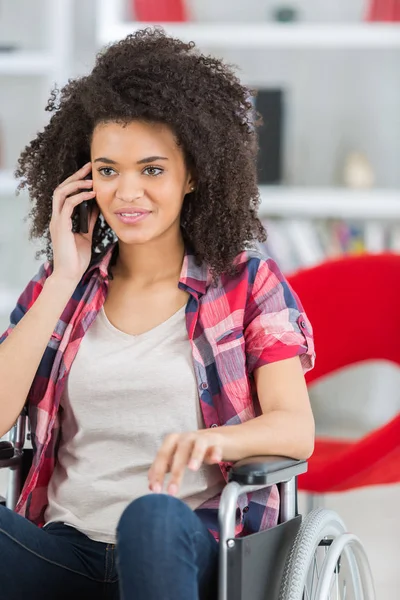 Ung kvinna i rullstol med mobiltelefon — Stockfoto