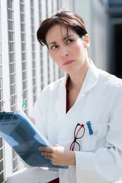 Fehér kabát női orvos mosolyogva — Stock Fotó