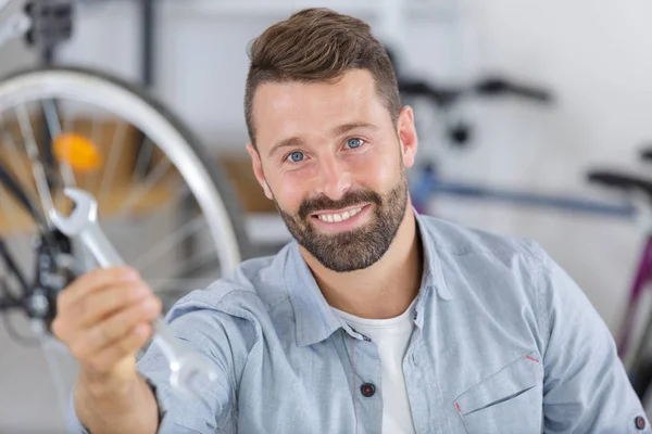 Homem mostrando chave na loja de bicicletas — Fotografia de Stock