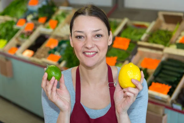 Mujer vendiendo verduras locales frescas en el mercado de agricultores — Foto de Stock