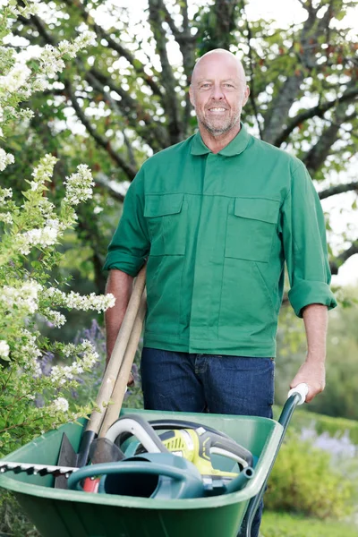 Ένας ευτυχισμένος κηπουρός που ποζάρει με καροτσάκι. — Φωτογραφία Αρχείου