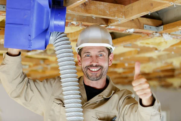 Byggare installera luftkonditionering enhet gör tummen upp gest — Stockfoto