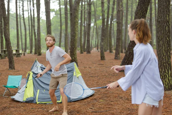 Um casal acampando jogando badminton — Fotografia de Stock