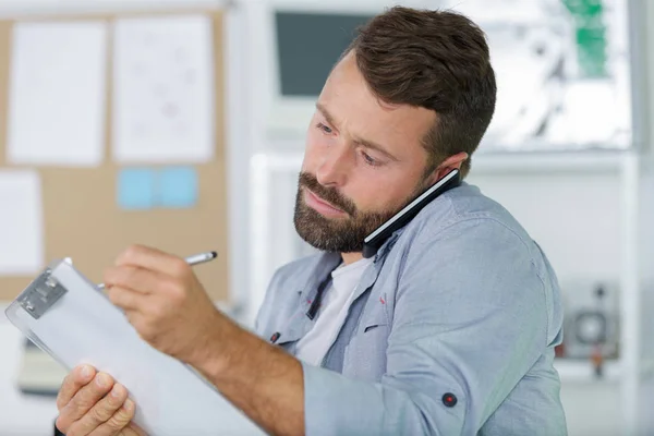 Man working taking notes on the phone — Stock Photo, Image