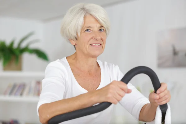 Ältere Dame trainiert auf Schritt-Maschine — Stockfoto