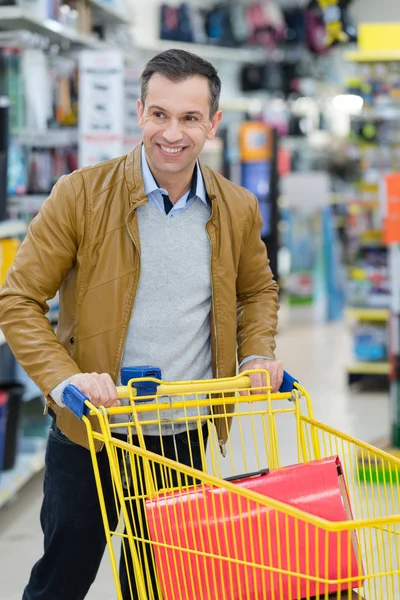 Homem comprando com carrinho de compras — Fotografia de Stock