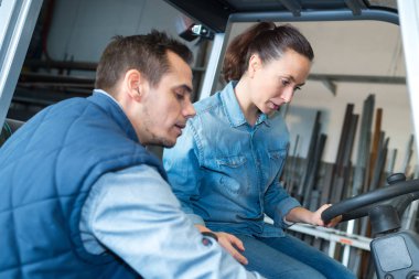 vocational instructor teaching female apprentice how to drive clipart