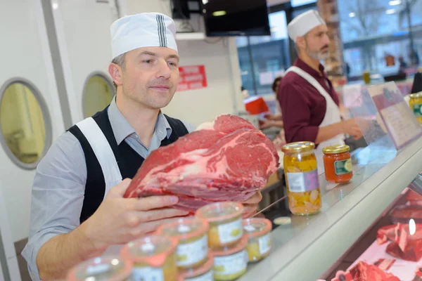 Metzger schneidet Fleisch und Metzger — Stockfoto