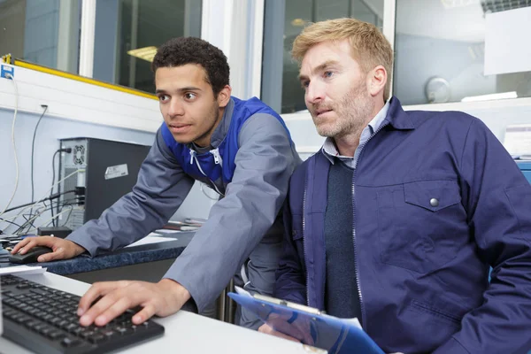 Двое мужчин держат в руках компьютер — стоковое фото