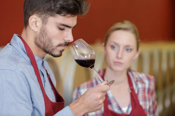 Casal de enólogos degustando vinho tinto — Fotografia de Stock