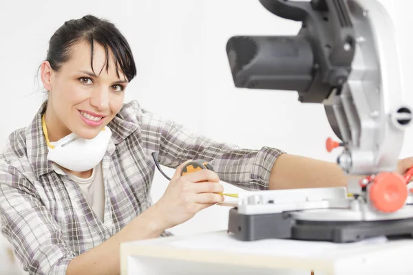 Vrouwelijke timmerman gebruiken cirkelzaag voor hout — Stockfoto