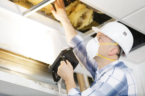 Hombre en constructor en uniforme y hardhat instalación de techo suspendido —  Fotos de Stock